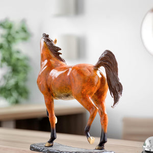 Arabian horse bronze sculpture displayed in living room beside window in natural light