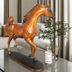 Arabian stallion bronze sculpture gold-brown finish displayed near window in natural light setting