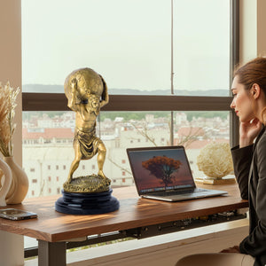 Atlas bronze sculpture gold finish side table beside wall art luxury interior