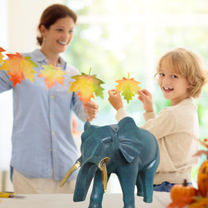 Blue bronze elephant statue in family lifestyle scene with parent and child enjoying home decor