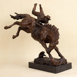 Rear angle view of large Bronco Buster bronze statue on polished black marble base, 14kg solid bronze