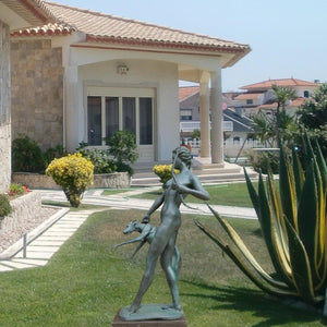 Bronze Greek goddess Artemis sculpture displayed along poolside corridor of luxury villa