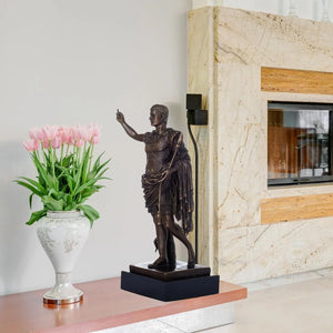 Bronze Augustus Caesar statue displayed beside fireplace with floral arrangement in indoor lifestyle setting