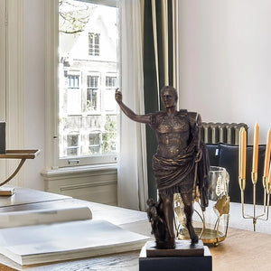 Bronze Augustus Caesar Roman emperor statue displayed by floor-to-ceiling window in luxury hallway