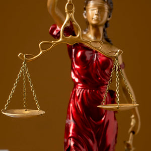 Bronze Lady Justice Themis statue in law office with male attorney handshake symbolizing justice