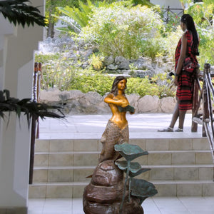 Bronze mermaid garden sculpture displayed beside luxury resort swimming pool