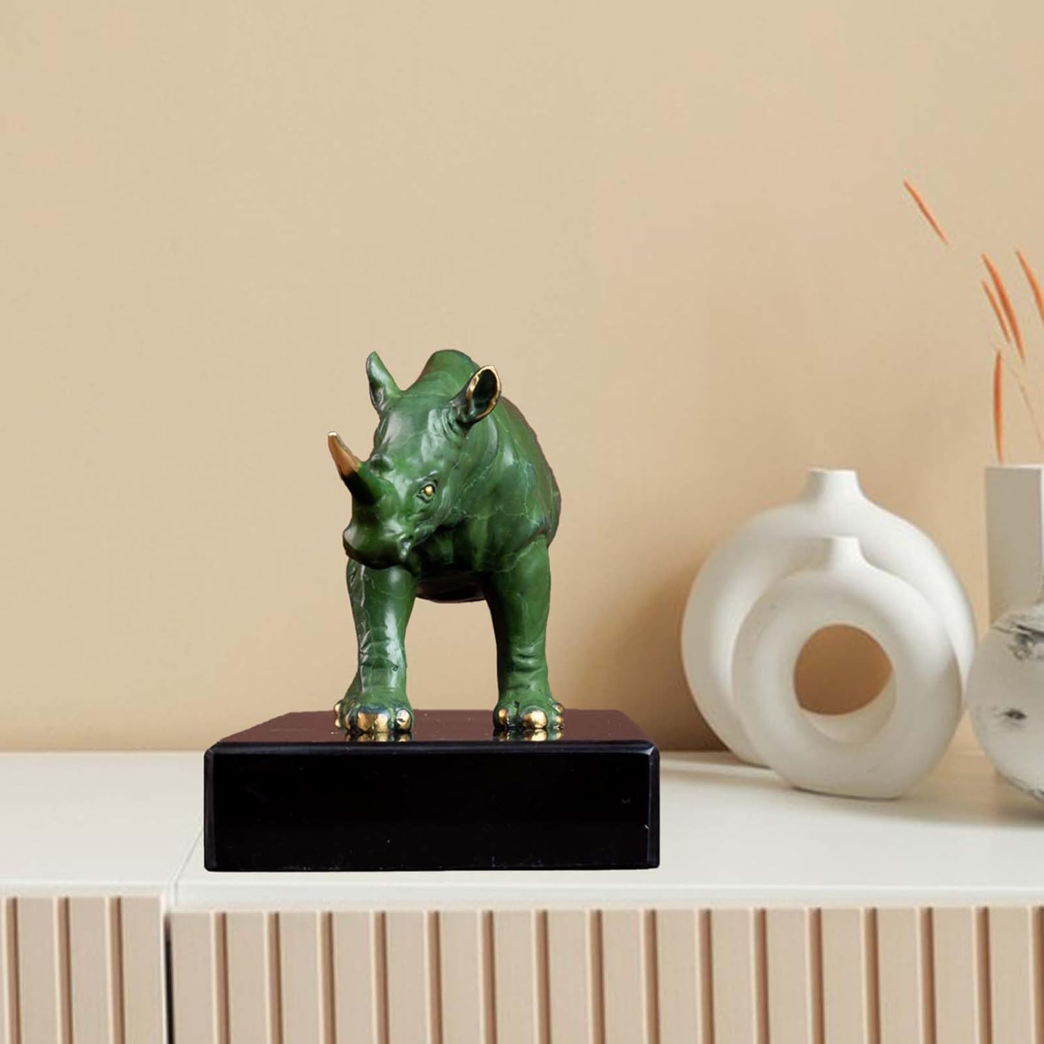 Side profile of the bronze rhino statue displayed on a black base.