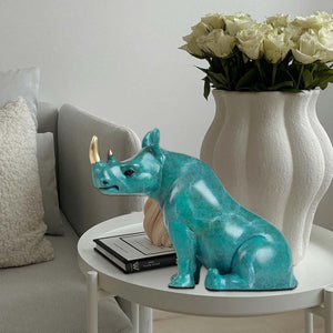 Handcrafted bronze rhino sculpture displayed on a tabletop.