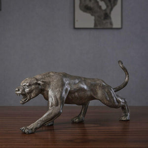 Bronze stalking panther statue displayed on indoor wooden desk as executive office decor