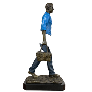 Close-up of the handcrafted bronze bag on the midnight navy traveler sculpture.