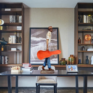 Close-up of the detailed facial features and classic hat on the bronze musician sculpture.