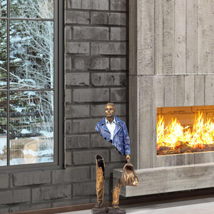 Detailed gold-patina weekend bag accessory on the standing voyageur sculpture.