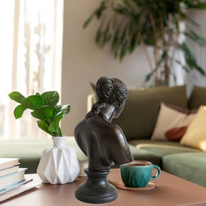 Bronze Venus de Milo bust statue displayed in modern living room with plant and sofa setting