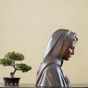Bronze Virgin Mary bust statue back angle view displayed with bonsai tree decor