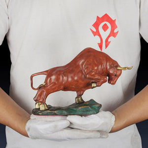 Orange-red bull figurine styled on an executive office desk.
