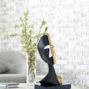 Cubist mask bronze sculpture in modern living room with sofa background as contemporary home decor