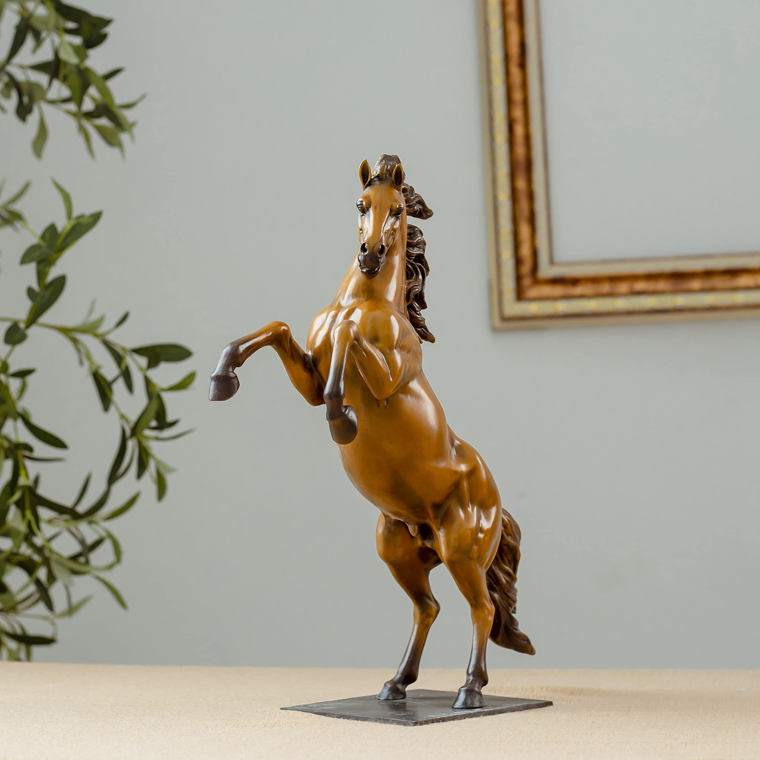Gold bronze rearing stallion desk edition sculpture displayed with framed art background