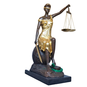 Front angle view of gilded bronze seated Lady Justice Themis statue holding scales on marble base