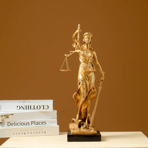 Gold Lady Justice Themis statue displayed with business card holder on professional lawyer desk