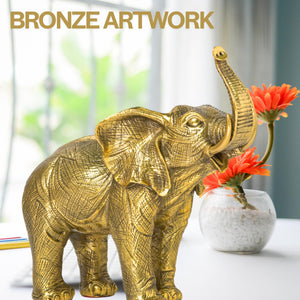 Golden brass elephant statue beside fireplace as majestic luxury home decor accent