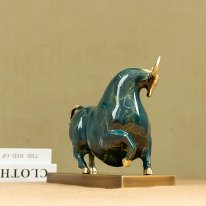 Close-up of green enamel bull head with golden horn finish.
