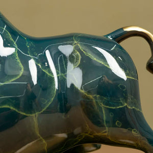 Close-up of the handcrafted brass hoof details on green bull.