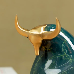 Detailed close-up of the polished golden horn on green bull.
