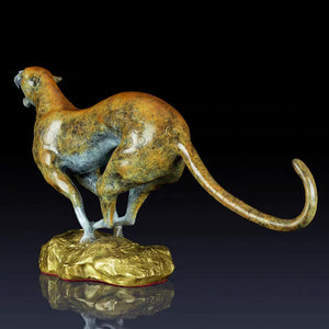 Back angle view of modern abstract bronze and gold cheetah wildlife sculpture on dark background