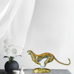 Modern abstract bronze cheetah sculpture styled in indoor setting alongside tea ceremony decor