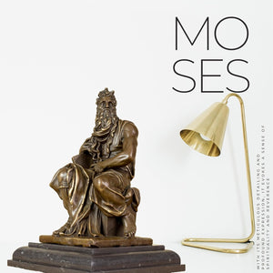 Moses bronze sculpture styled as home decor next to books and plants on a bookshelf