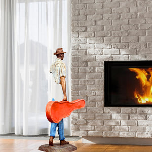 Detailed view of the vibrant orange guitar case accessory on the standing traveler sculpture.