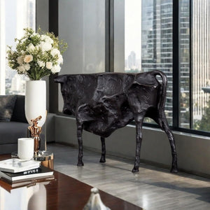 Black bull sculpture styled on a modern red office desk.