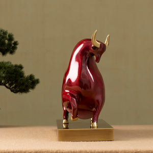 Close-up of red enamel bull head with golden horn finish.
