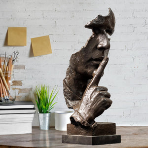 Side profile of black Silence is Gold abstract thinker bronze statue on marble base