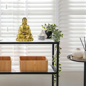 Solid brass Buddha statue shown in two lifestyle scenes: desk display and meditation setting with lamp