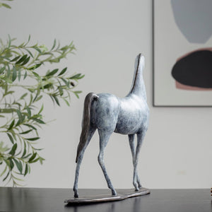 White bronze minimalist horse sculpture back angle view displayed in modern interior setting