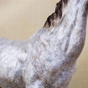 Close-up detail of white bronze horse sculpture back and mane showing dappled gray texture