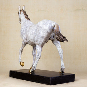 Front angle view of white bronze walking horse sculpture showing dynamic walking pose and dappled texture