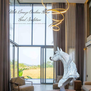 White patina bronze Arabian horse head sculpture displayed in living room with countryside window view