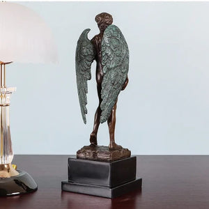 Back view of winged David bronze sculpture on dark wood desk showing spread wings and marble base