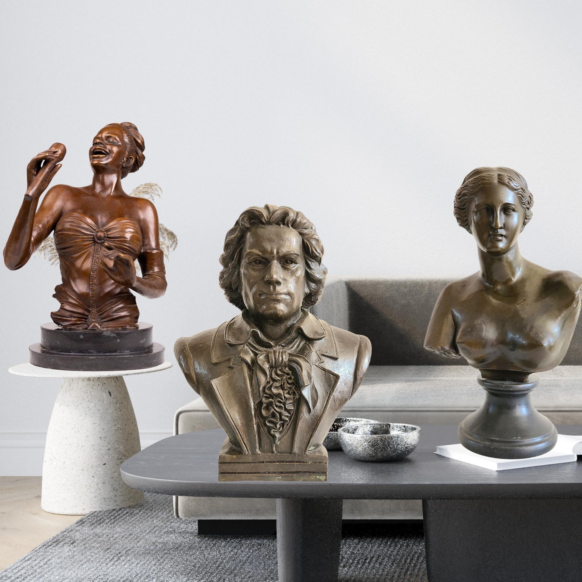 Handcrafted bronze portrait busts including a Beethoven composer statue, Venus de Milo bust, and a female jazz singer sculpture displayed on a modern table.