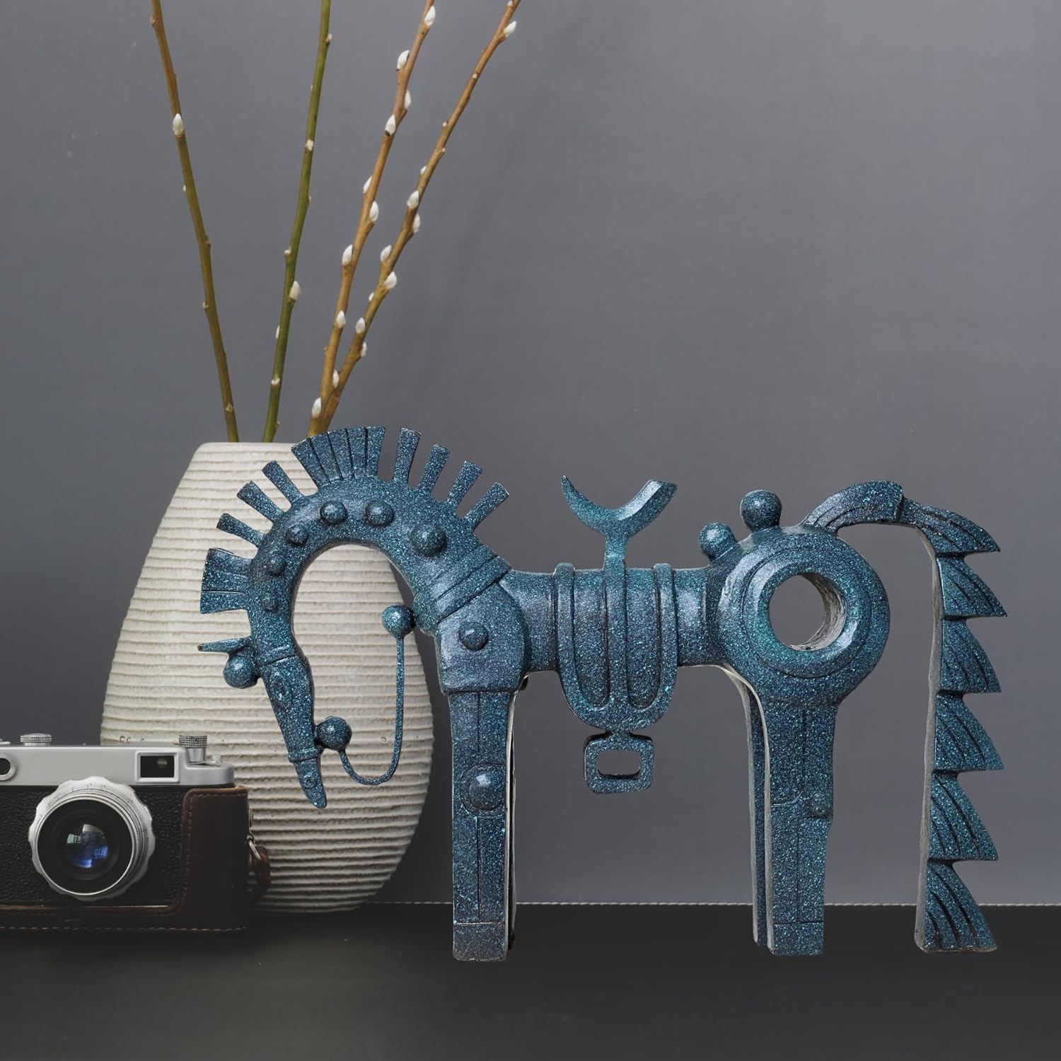 Abstract geometric bronze horse sculpture angle view displayed with indoor plant decor