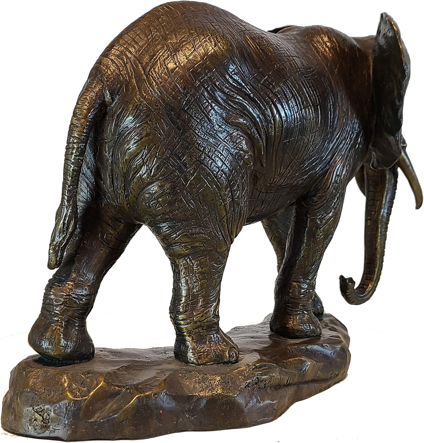 Back view of African elephant bronze statue showing detailed body texture and natural rock base