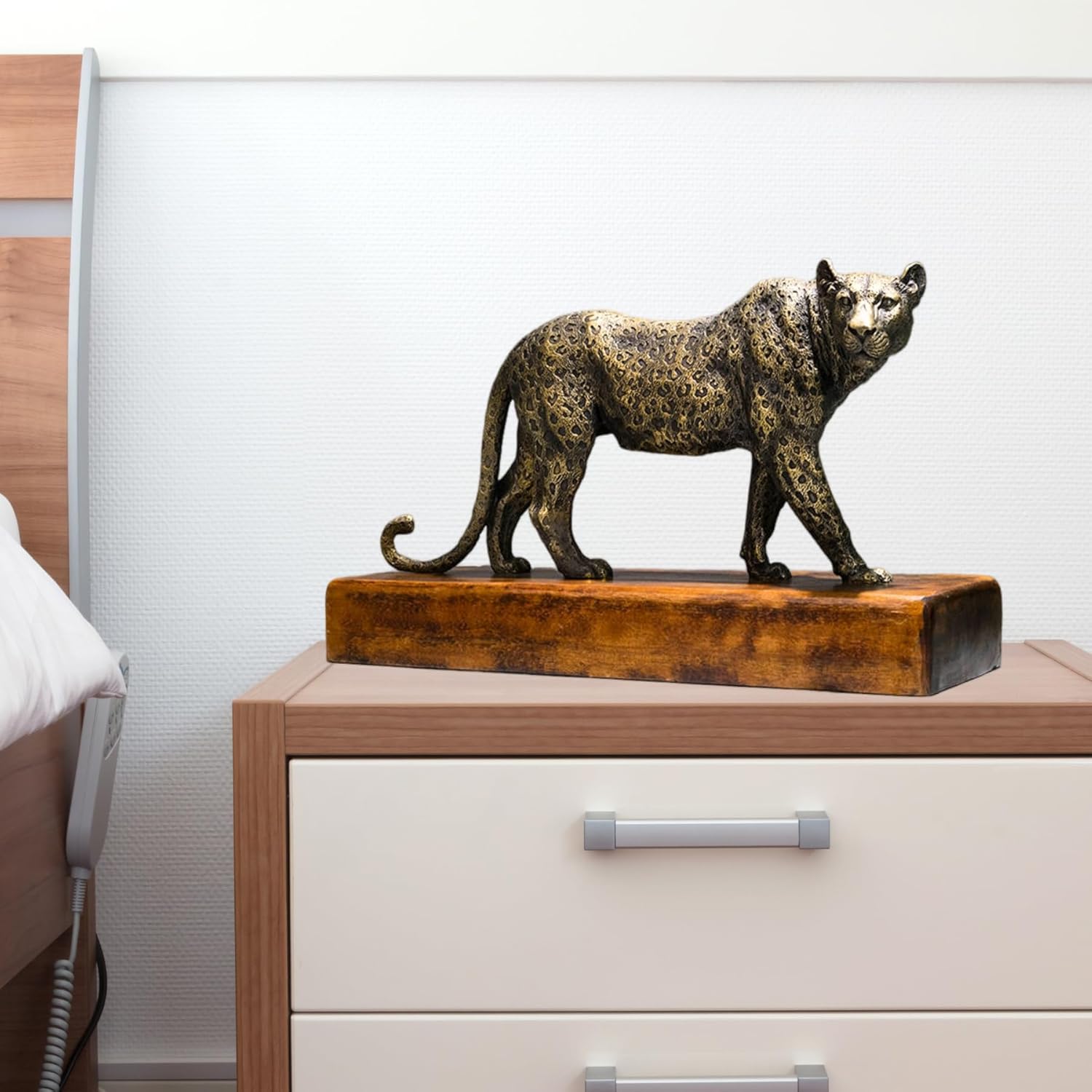 Antique bronze money leopard sculpture displayed on bedroom side cabinet as luxury decor