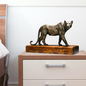 Antique bronze money leopard sculpture displayed on bedroom side cabinet as luxury decor