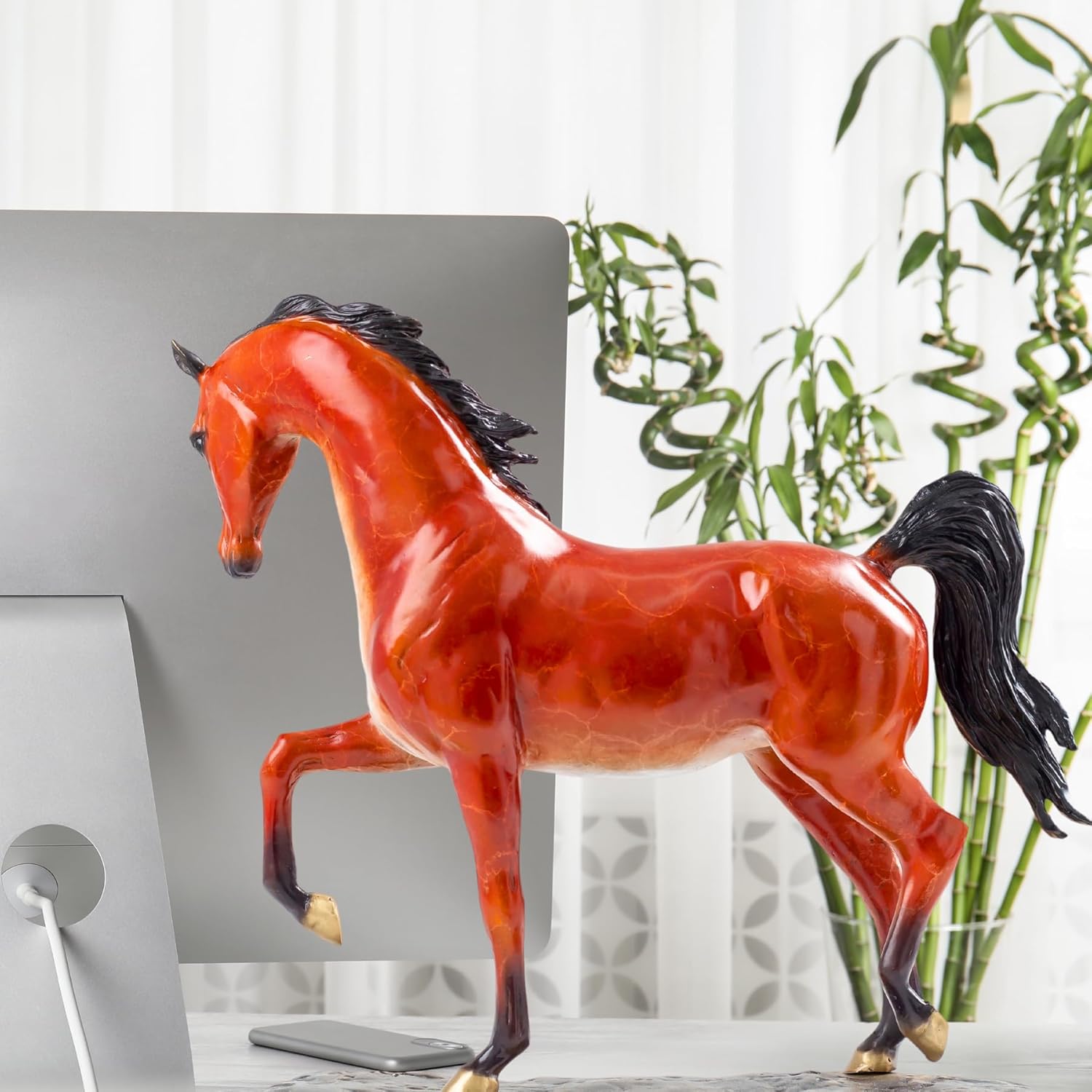 Arabian horse bronze sculpture displayed on table beside sofa and indoor plant as home decor