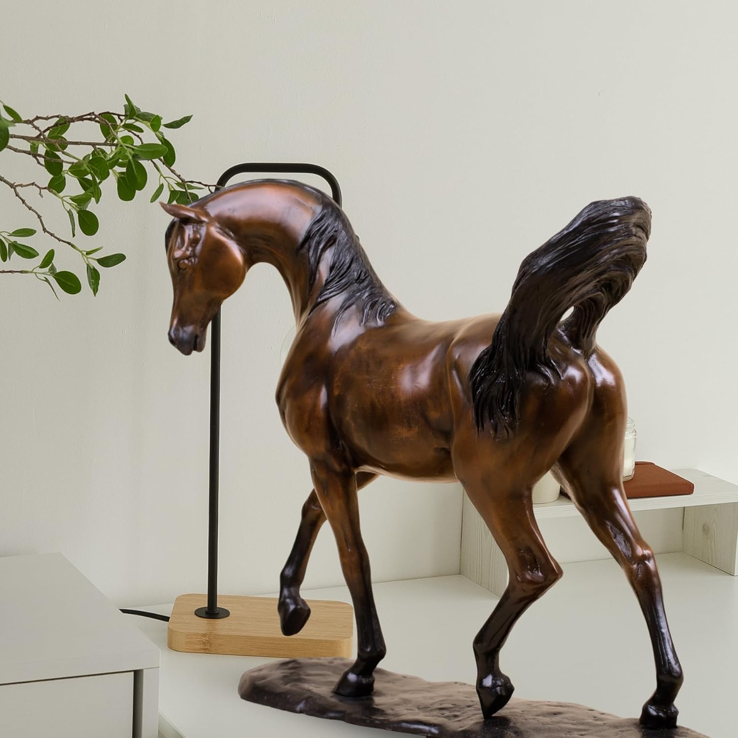 Antique chestnut Arabian stallion bronze sculpture displayed beside plant in modern living room