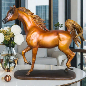 Arabian stallion bronze sculpture gold-brown finish displayed on shelf beside indoor plant