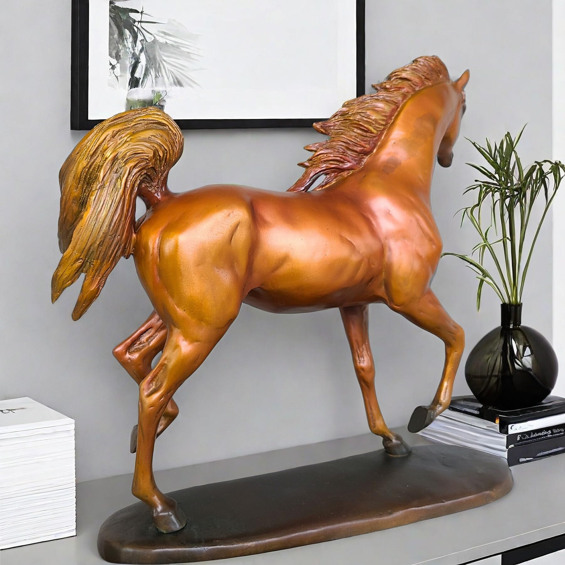 Arabian stallion bronze sculpture in gold-brown finish displayed on table beside vase and plant