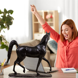 Midnight black Arabian stallion bronze sculpture displayed in bright living room interior setting